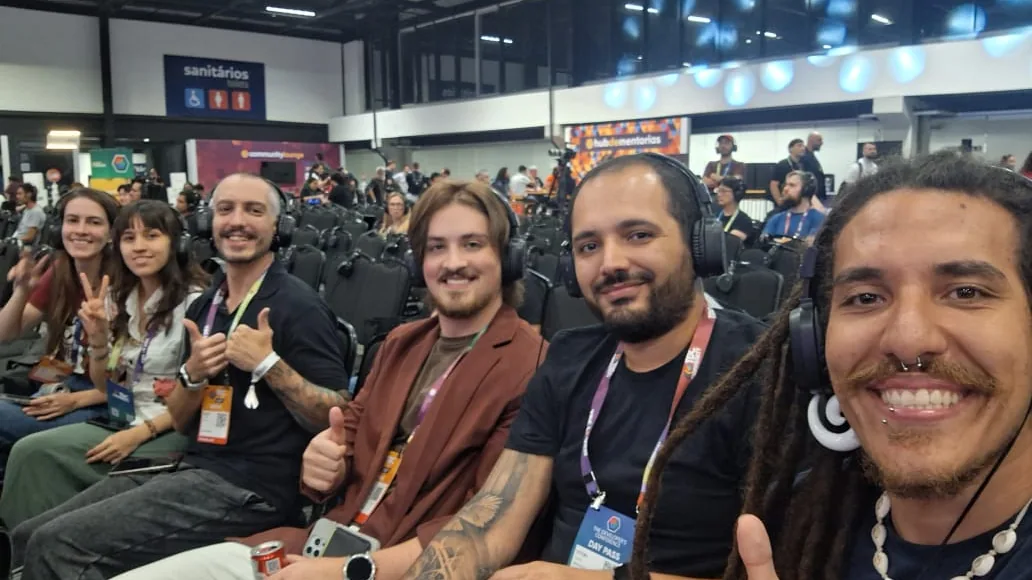 corredor de feira de tecnologia com o grupo reunido e o público ao fundo